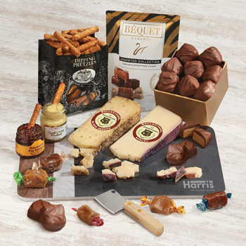 Magnificent Assortmentof cheese, dipping pretzels with fig spread and sweet & hot mustard, peanut butter meltaways and assorted caramels on a branded cutting board